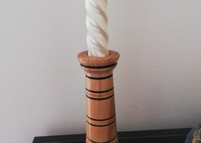 Bougeoir en bois tourné artisanal, chandelier en bois clair avec rainures décoratives sombres, objet de décoration intérieure fait main, présenté avec bougie